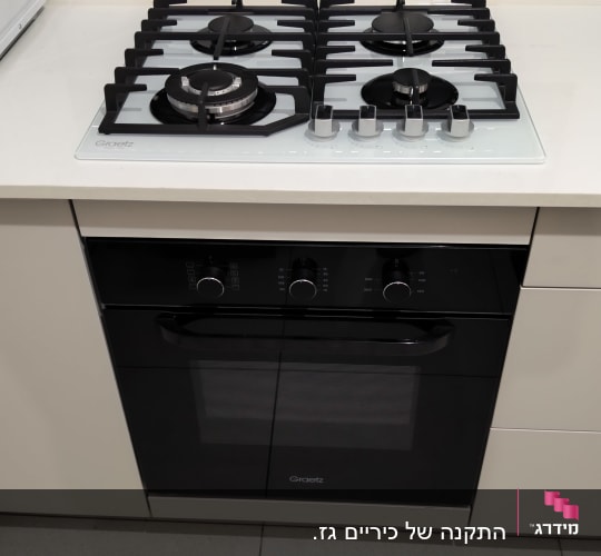 כיריים גז לבנות מותקנות על משטח עבודה במטבח מודרני